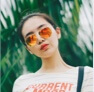 profile photo of a women wearing a white tea shirt wearing orange sunglasses